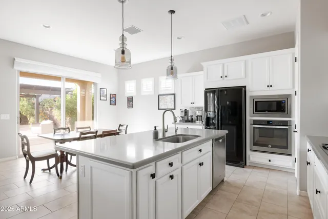 a kitchen with stainless steel appliances granite countertop a sink a stove and a refrigerator