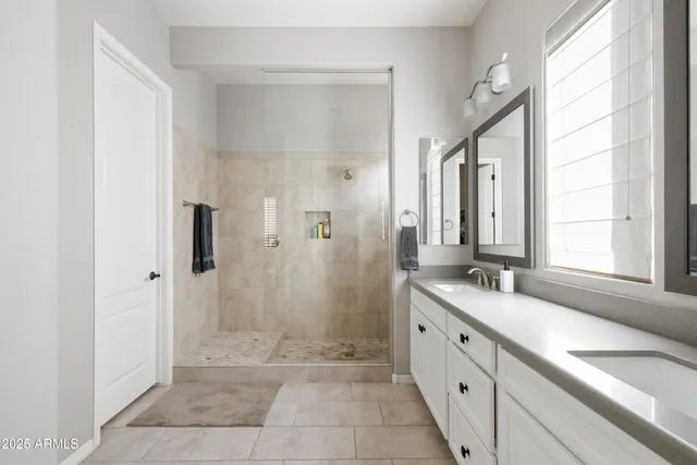 a spacious bathroom with a granite countertop sink mirror and shower