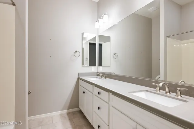 a bathroom with a double vanity sink and a mirror