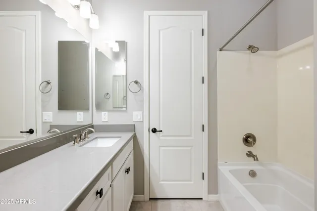 a bathroom with a granite countertop sink a mirror a shower and a bathtub