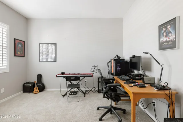 a view of a workspace with furniture and a window