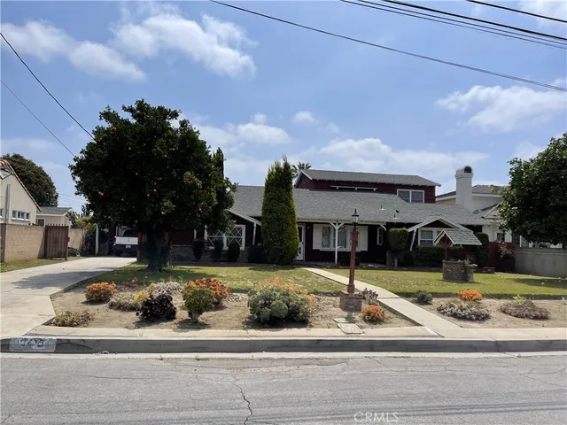 a front view of a house with a garden and plants