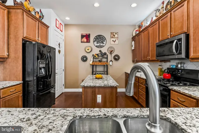 a kitchen with stainless steel appliances granite countertop a refrigerator stove top oven a sink and dishwasher
