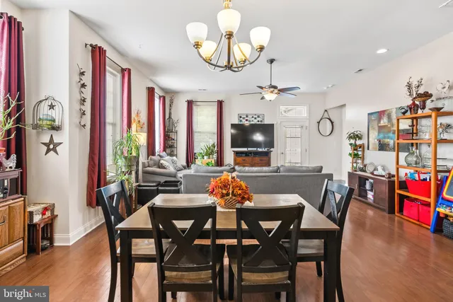 a dining room with furniture a large window and wooden floor