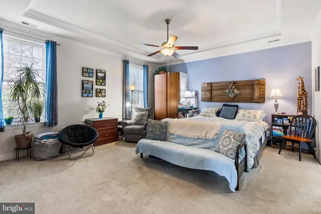 a bedroom with a bed a couch and a chandelier