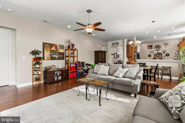 a living room with furniture kitchen view and a chandelier