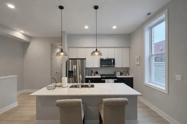 a kitchen with kitchen island a sink stove and refrigerator