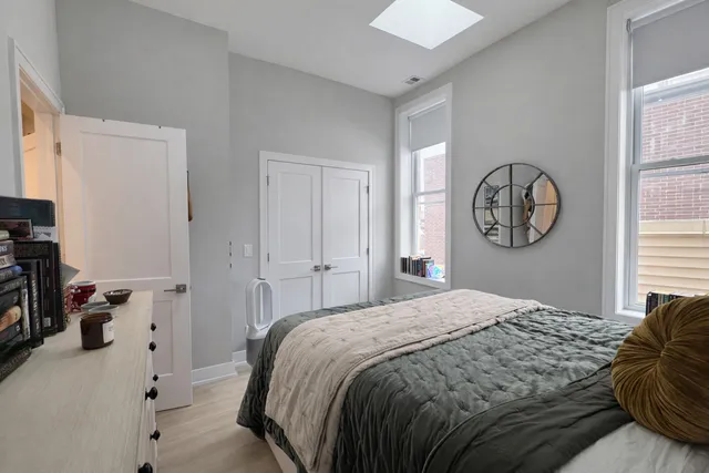 a bedroom with a bed a mirror and a window