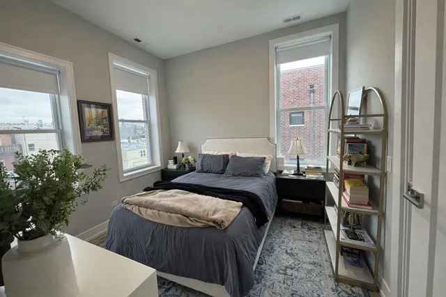 a bedroom with a bed and a potted plant