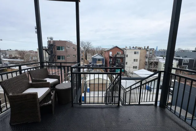 a view of a balcony with two chairs and a table