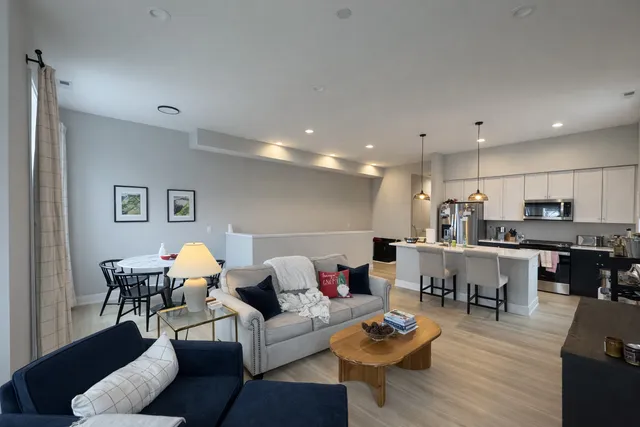 a living room with furniture kitchen view and a dining table