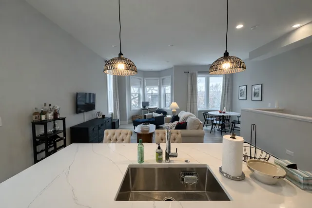 a very nice looking dining room with a large window and chandelier