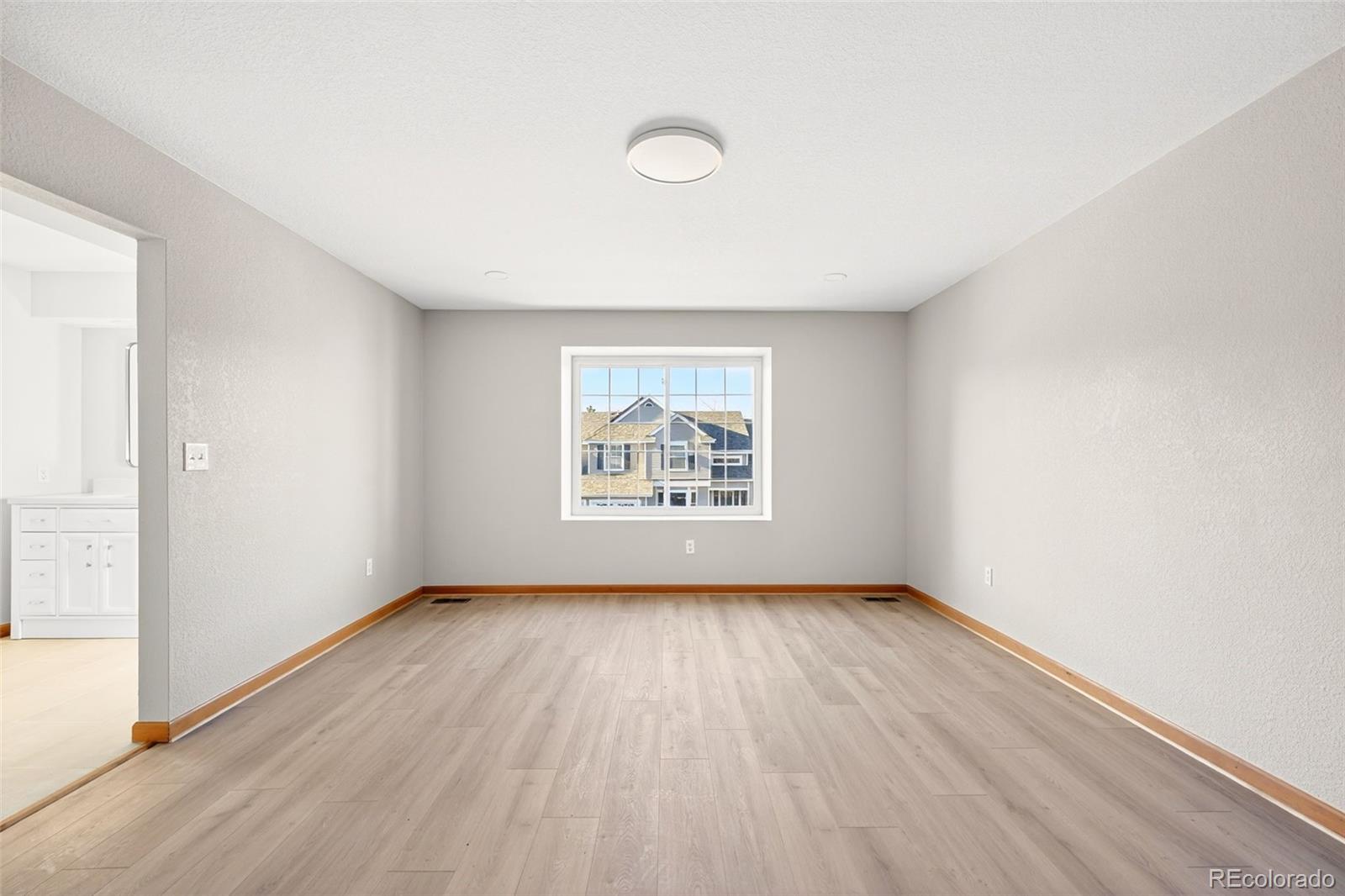 8852 Chestnut Hill Lane Highlands Ranch, CO 80130 - Photo 19 of 38 an empty room with wooden floor and windows