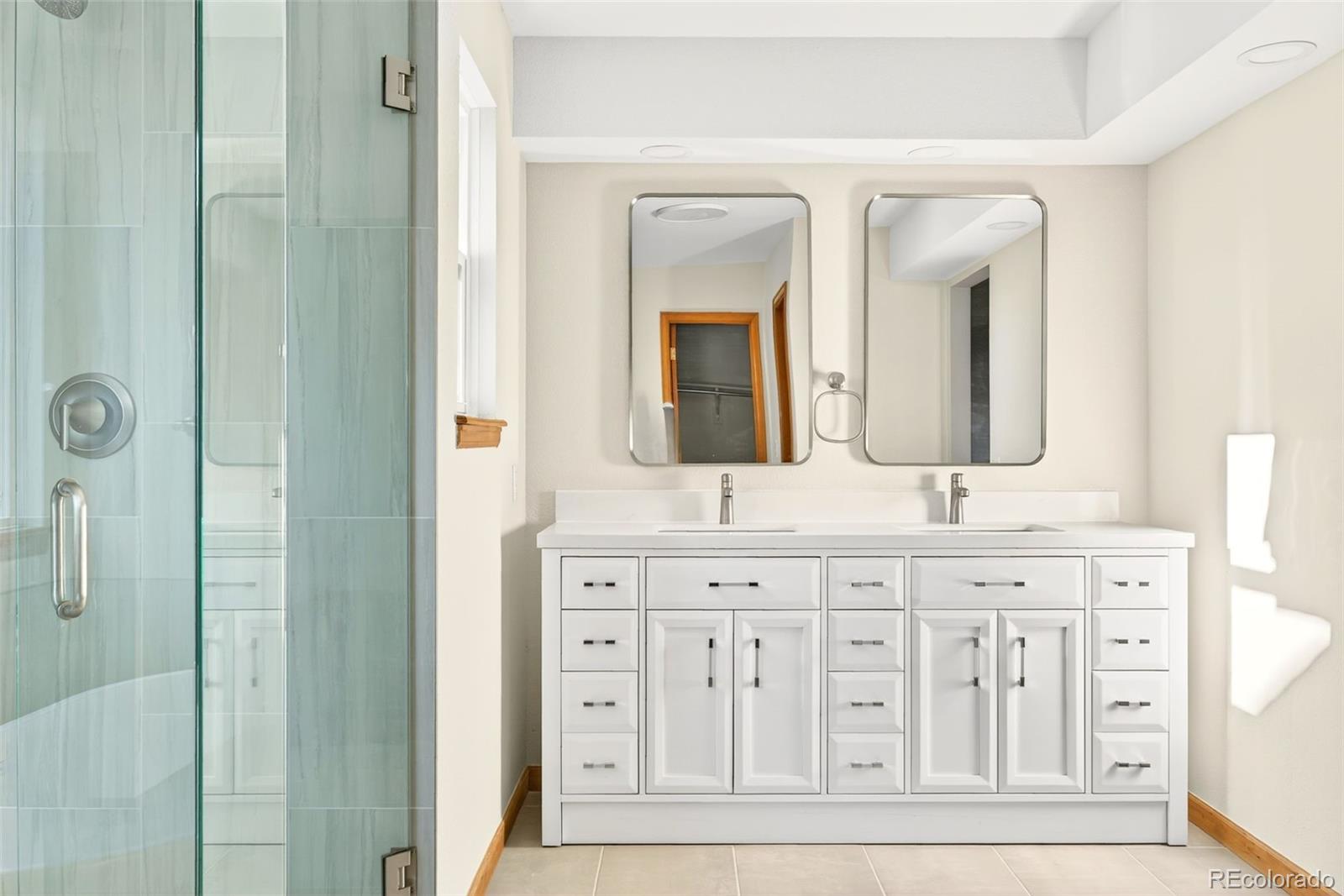 8852 Chestnut Hill Lane Highlands Ranch, CO 80130 - Photo 20 of 38 a bathroom with double vanity sinks and a mirror