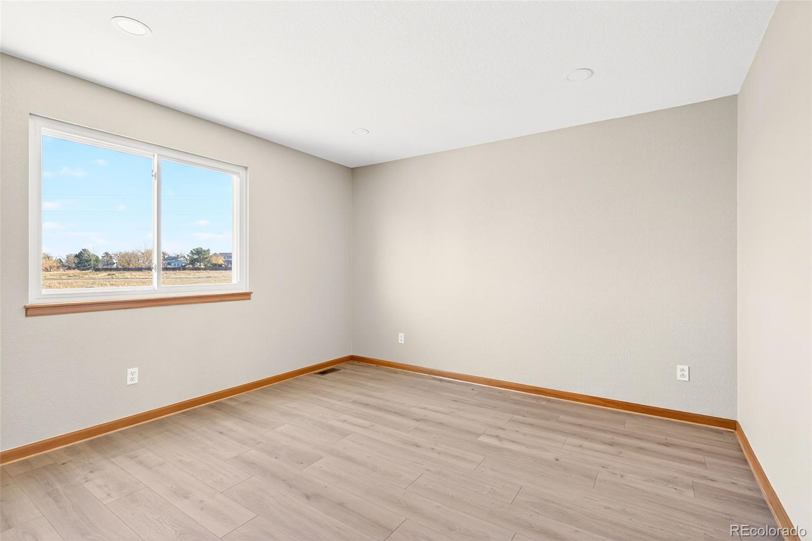 8852 Chestnut Hill Lane Highlands Ranch, CO 80130 - Photo 22 of 38 a view of an empty room with wooden floor and a window