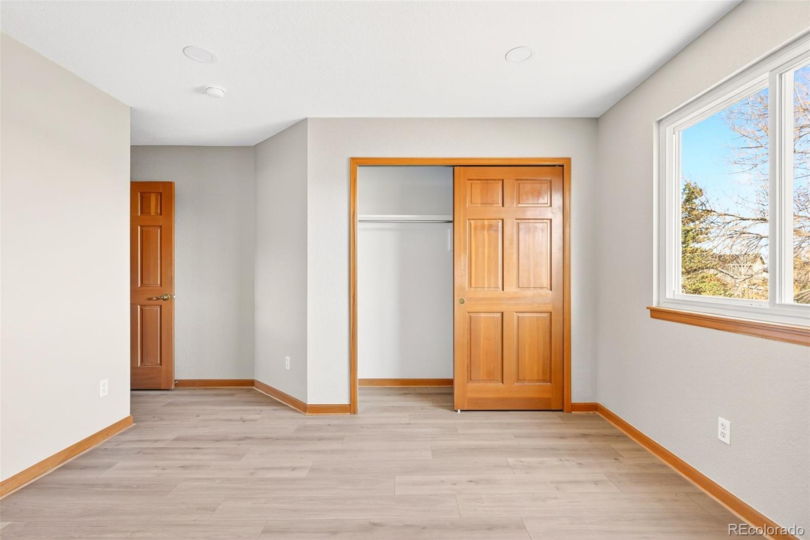 8852 Chestnut Hill Lane Highlands Ranch, CO 80130 - Photo 23 of 38 an empty room with wooden floor and windows