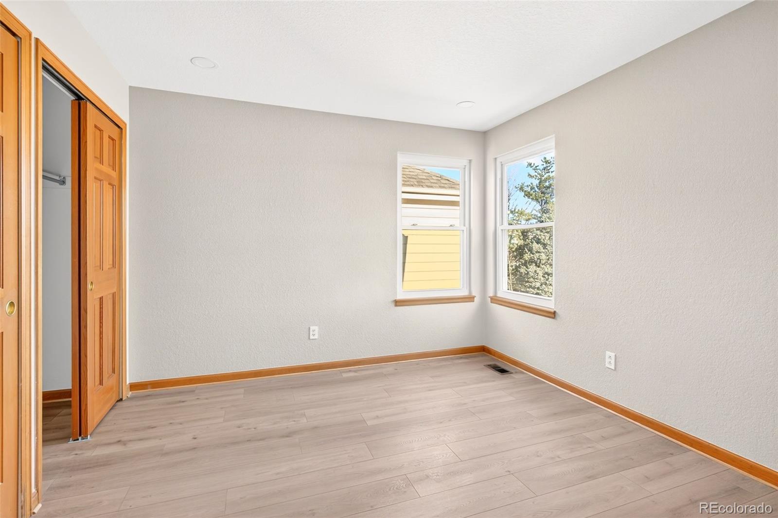 8852 Chestnut Hill Lane Highlands Ranch, CO 80130 - Photo 24 of 38 an empty room with wooden floor and windows