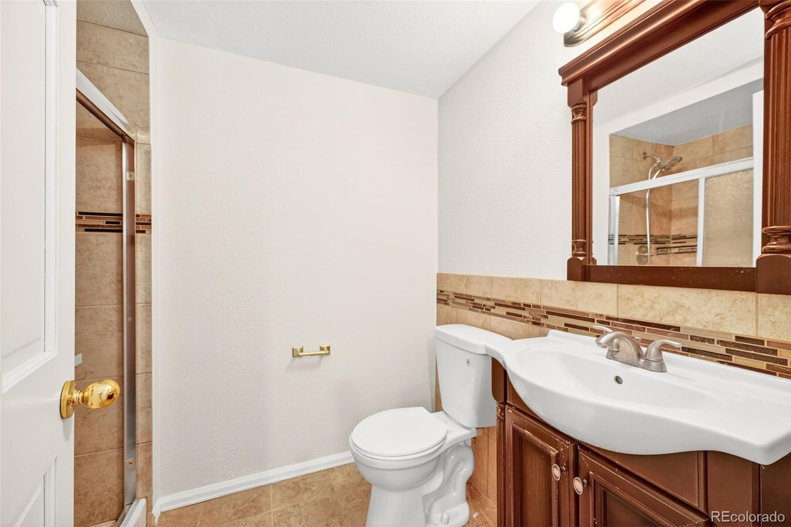 8852 Chestnut Hill Lane Highlands Ranch, CO 80130 - Photo 30 of 38 a bathroom with a sink toilet and a mirror