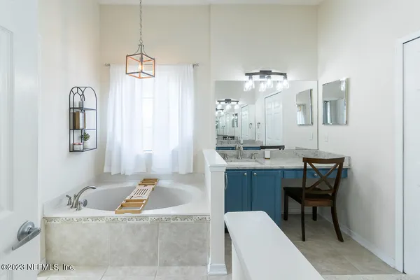 a spacious bathroom with a bathtub shower sink and mirror