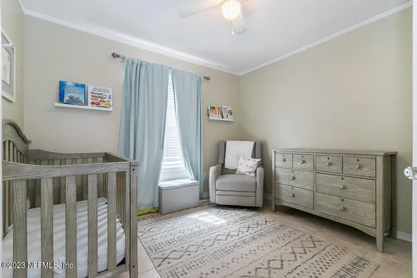 a living room with furniture and a baby crib