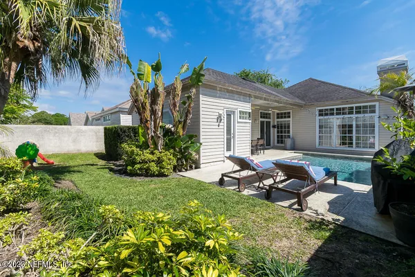 a view of a house with backyard and sitting area