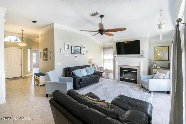 a living room with furniture a fireplace and a flat screen tv