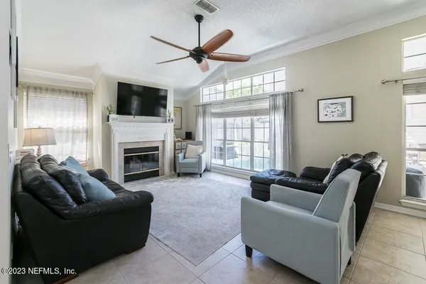 a living room with furniture a fireplace and a flat screen tv