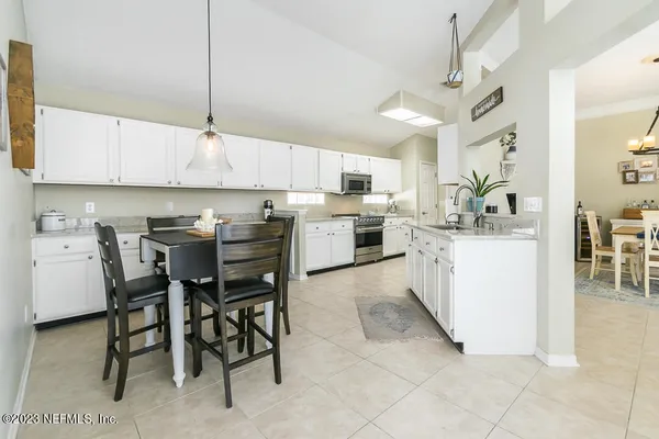 a kitchen with a table chairs microwave and cabinets