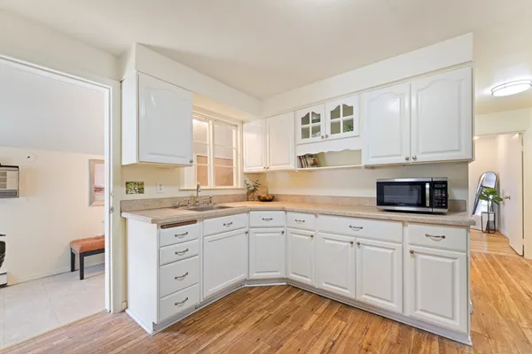 a kitchen with a sink cabinets and wooden floor