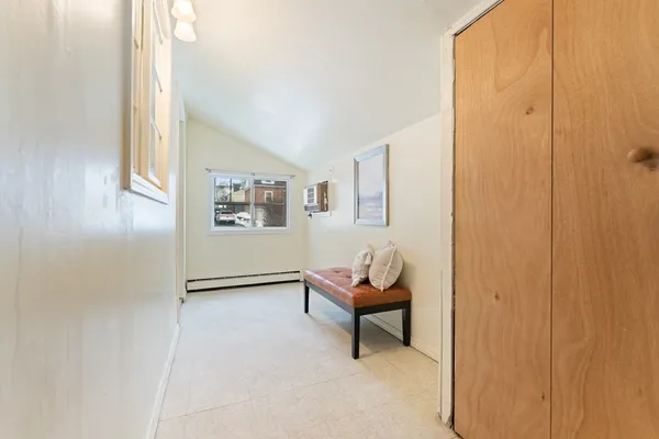 a view of a hallway with wooden floor and a bathroom