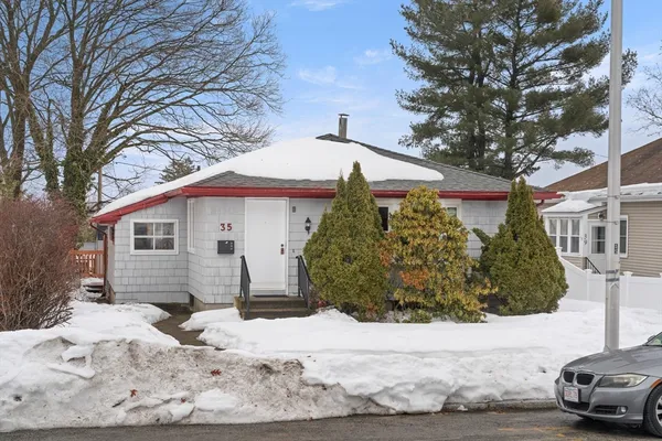 a front view of a house with a yard covered in snow