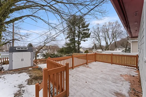 a view of a roof deck with wooden fence and trees