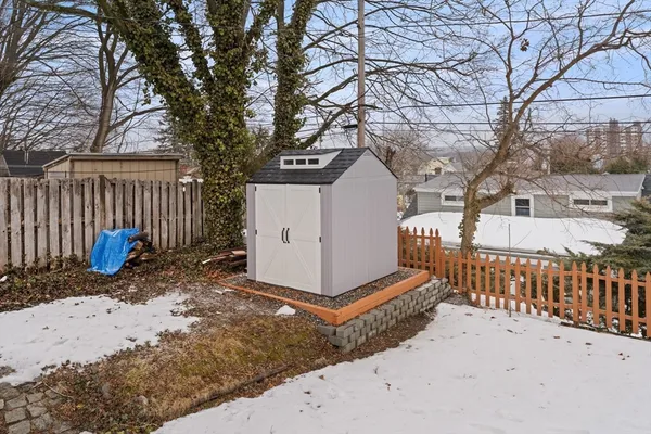 a view of a house with a small yard and wooden fence