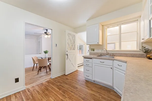 a kitchen with granite countertop a sink cabinets and wooden floor