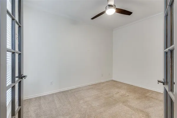 an empty room with a ceiling fan and a window