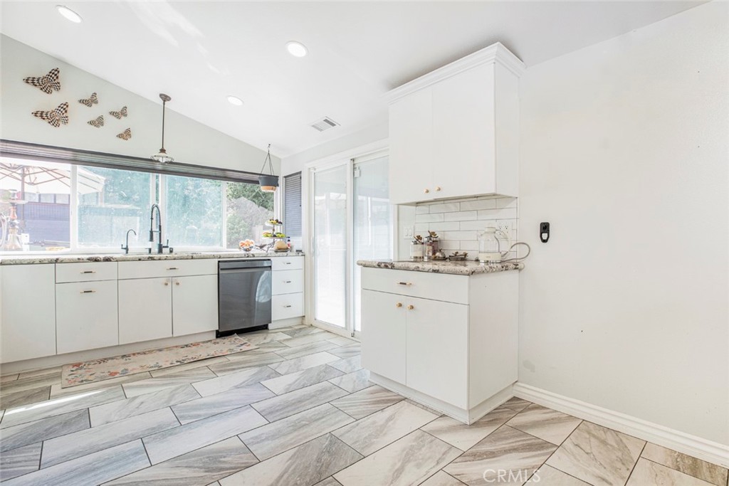 18810 Kirkcolm Lane Porter Ranch, CA 91326 - Photo 18 of 75 a kitchen with a sink a stove and white cabinets