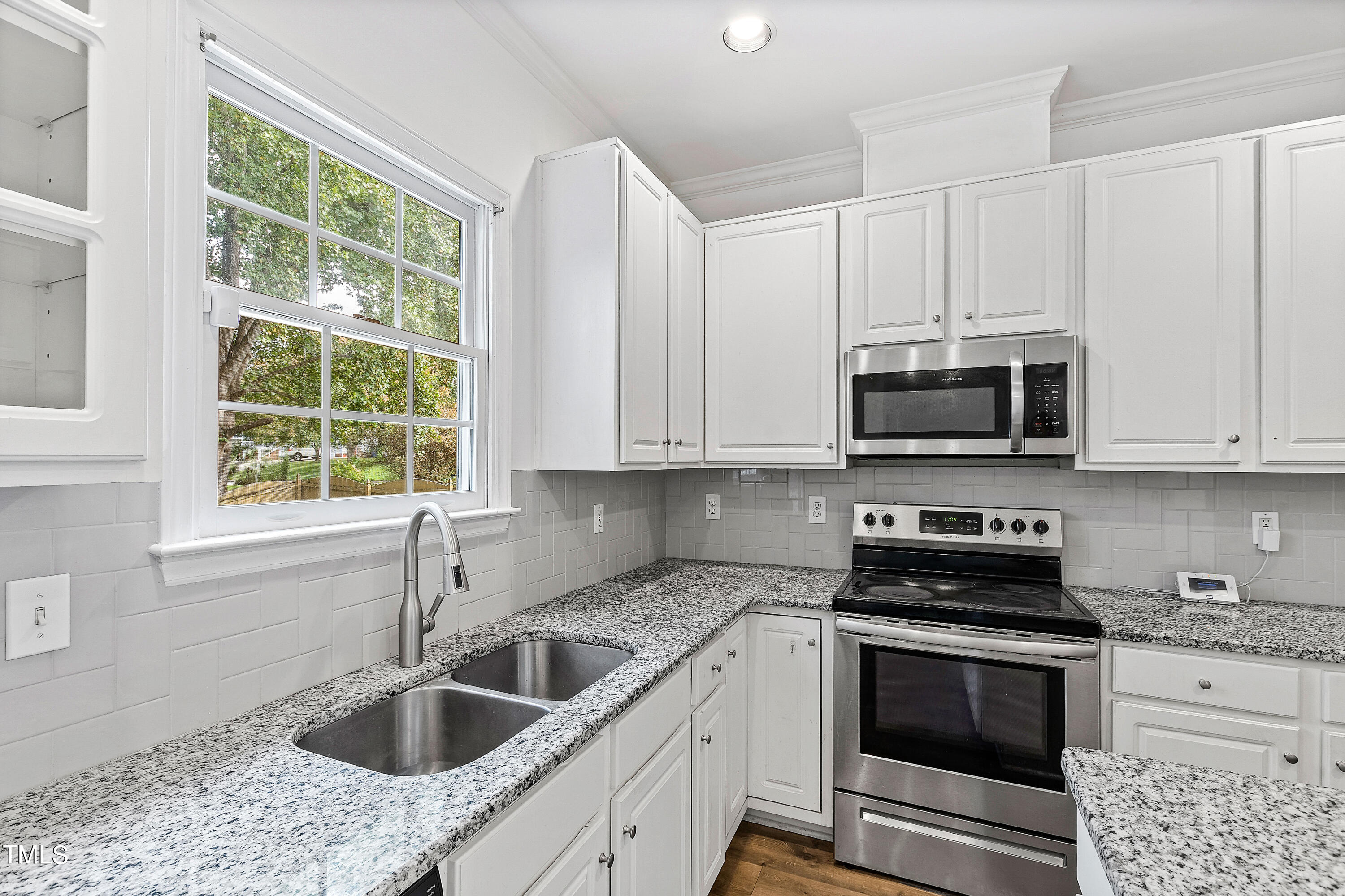 4305 Riverport Road Raleigh, NC 27616 - Photo 15 of 43 a kitchen with granite countertop white cabinets sink and stainless steel appliances