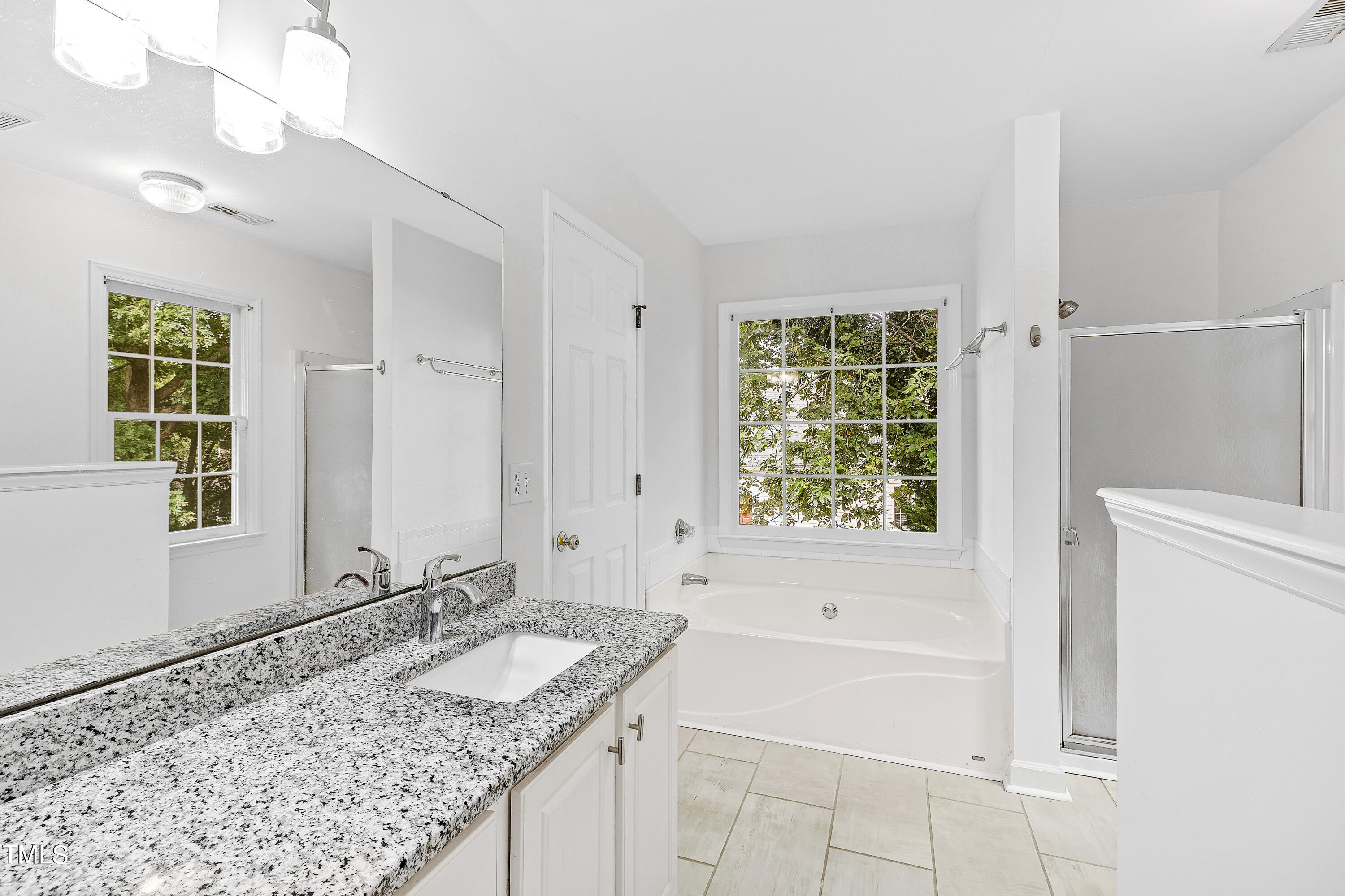 4305 Riverport Road Raleigh, NC 27616 - Photo 23 of 43 a bathroom with a granite countertop tub a sink and a window