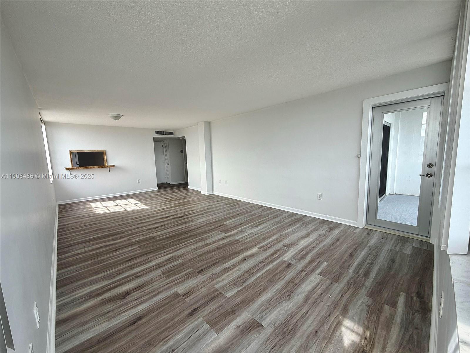 8000 Harding Avenue, Unit 5C Miami Beach, FL 33141 - Photo 1 of 13 a view of empty room with wooden floor