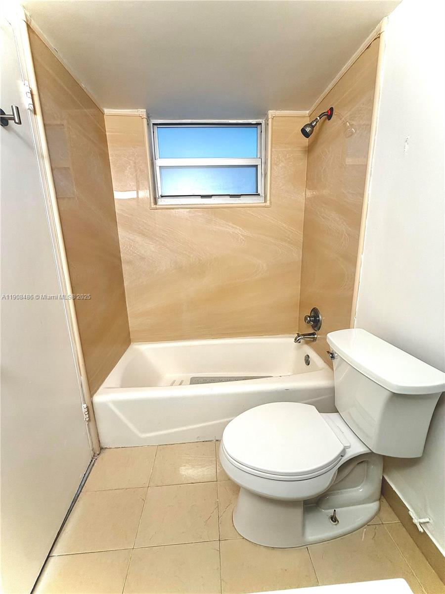 8000 Harding Avenue, Unit 5C Miami Beach, FL 33141 - Photo 11 of 13 a bathroom with a toilet and a bath tub