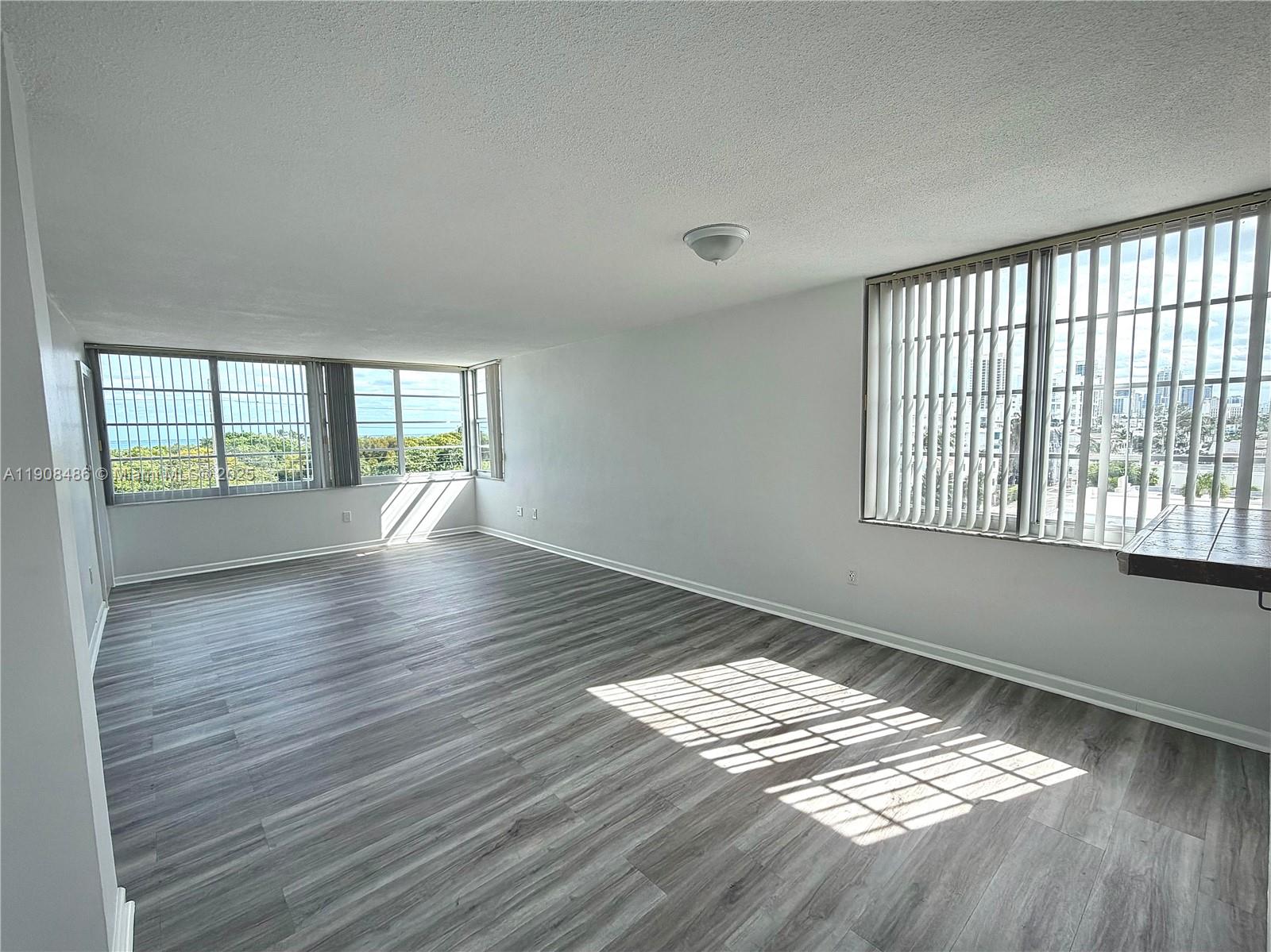 8000 Harding Avenue, Unit 5C Miami Beach, FL 33141 - Photo 2 of 13 wooden floor in an empty room with a window