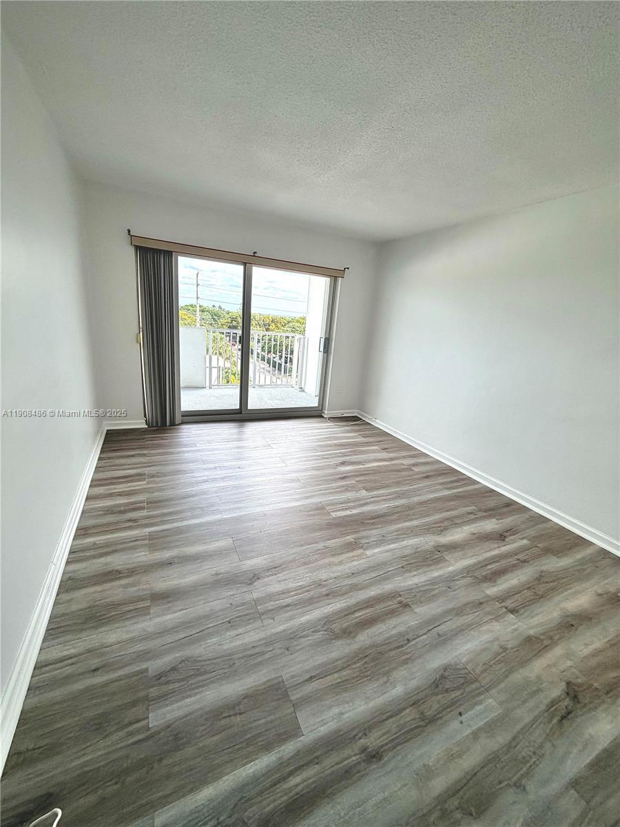 8000 Harding Avenue, Unit 5C Miami Beach, FL 33141 - Photo 5 of 13 a view of an empty room with wooden floor and a window