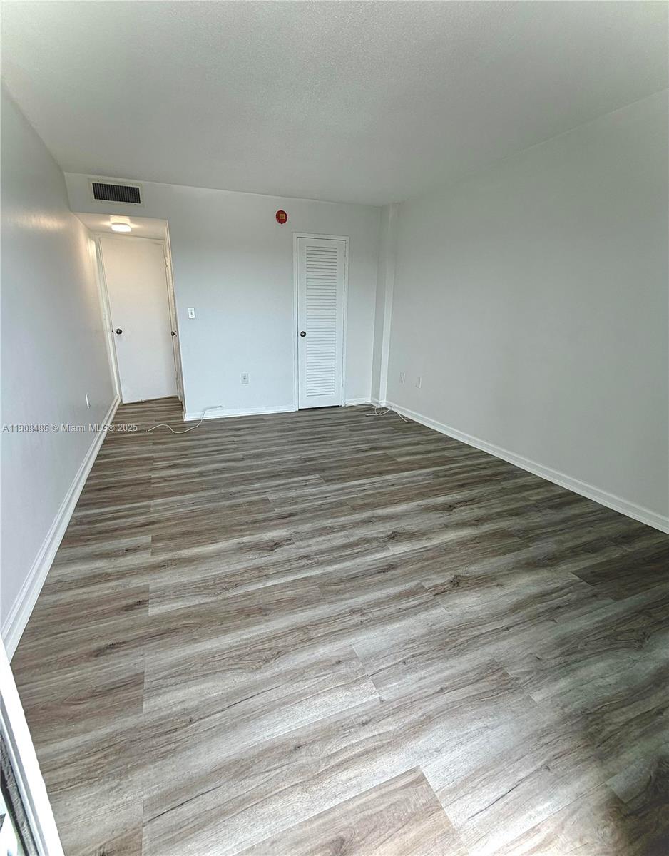 8000 Harding Avenue, Unit 5C Miami Beach, FL 33141 - Photo 8 of 13 a view of empty room with wooden floor
