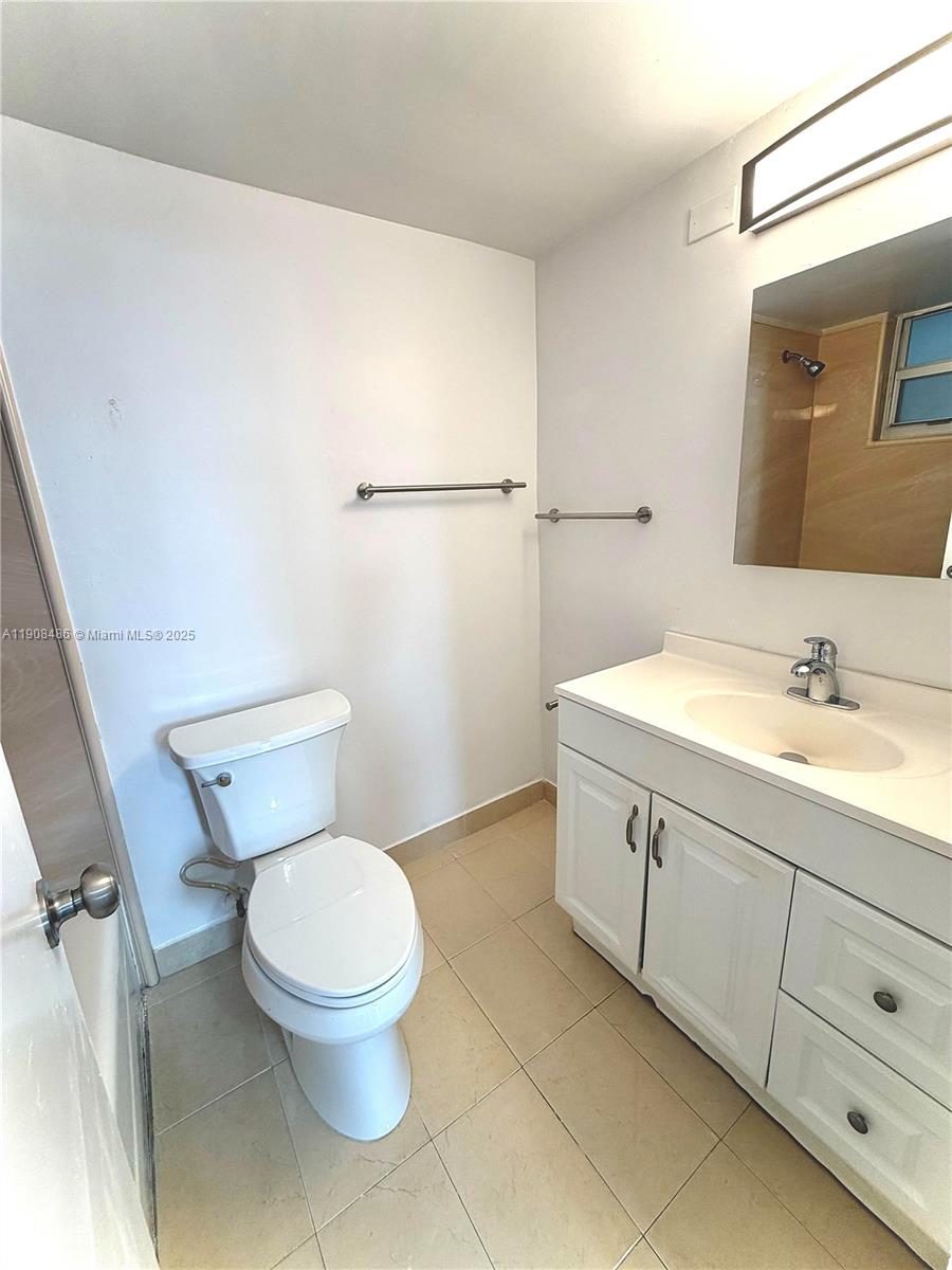 8000 Harding Avenue, Unit 5C Miami Beach, FL 33141 - Photo 10 of 13 a bathroom with a toilet sink and mirror