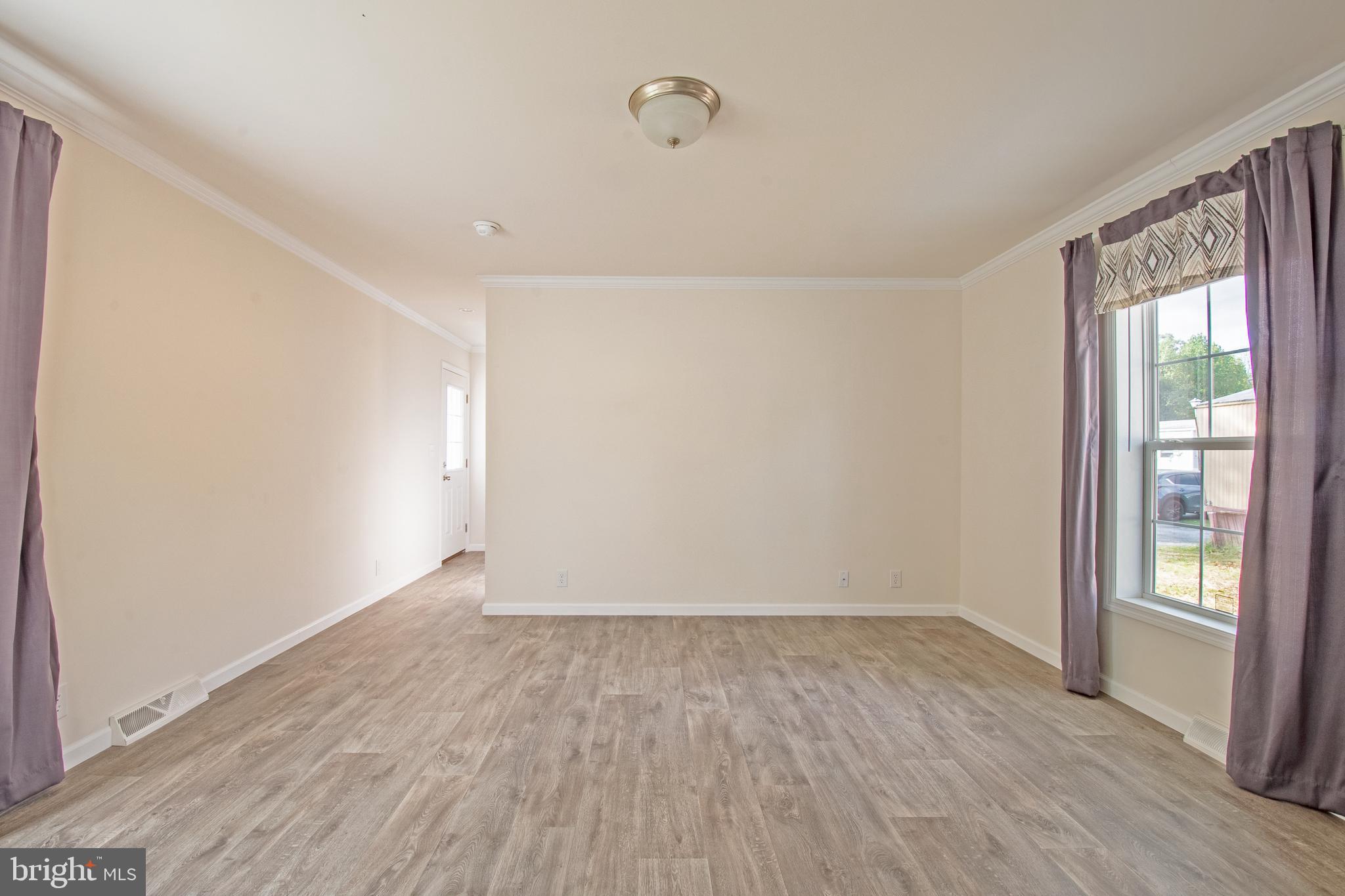 91 Longbow Lane Hartly, DE 19953 - Photo 13 of 21 a view of an empty room with wooden floor and a window