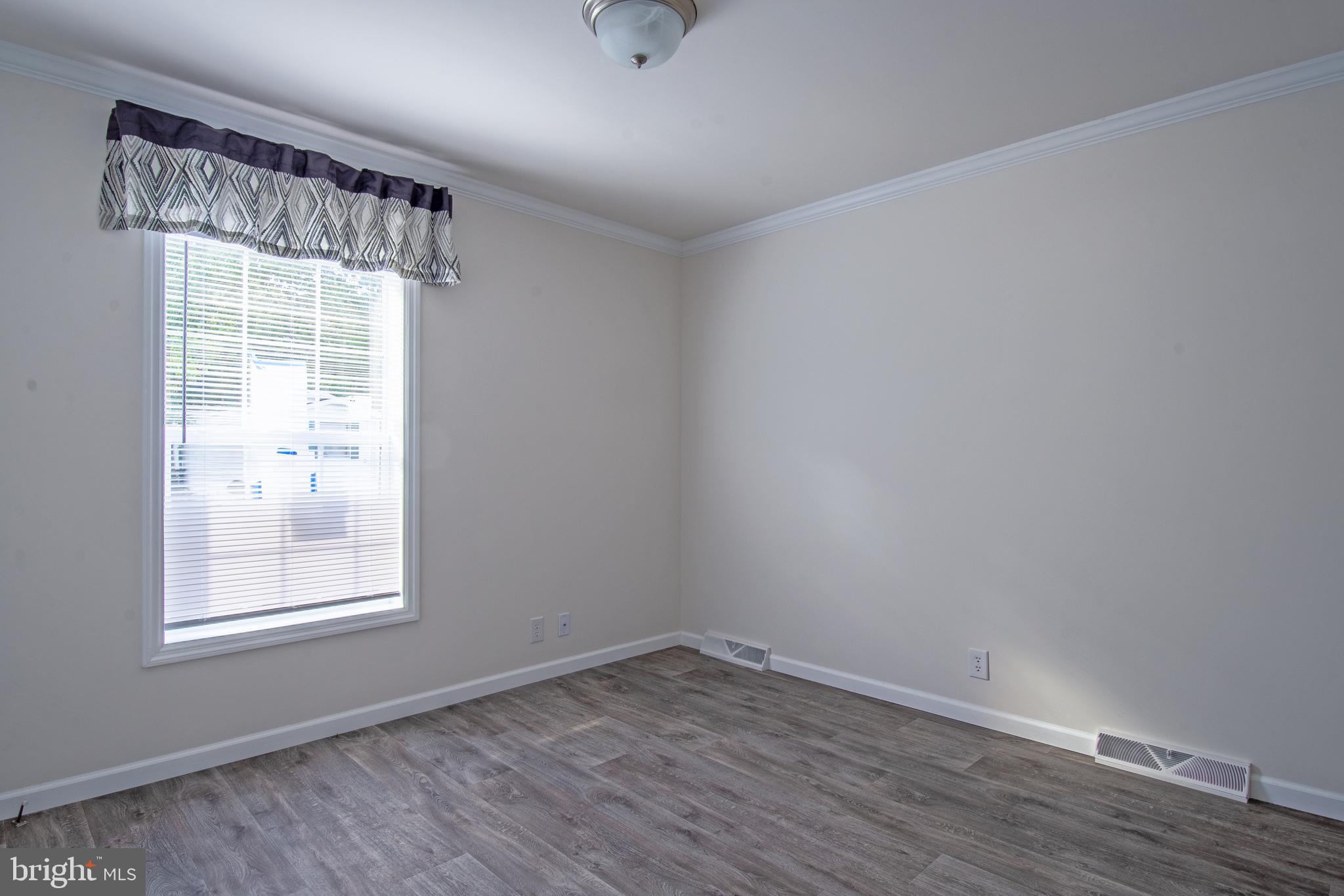 91 Longbow Lane Hartly, DE 19953 - Photo 21 of 21 a view of an empty room with wooden floor and a window