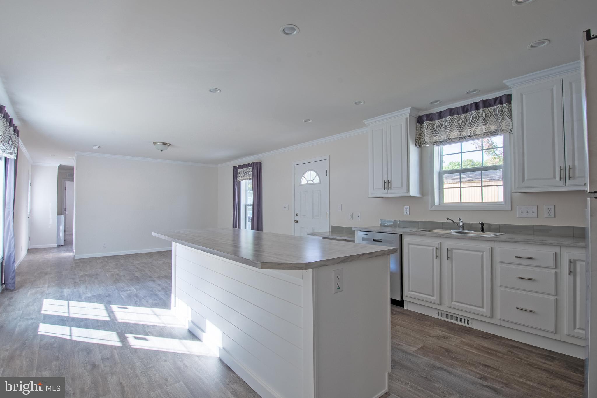 91 Longbow Lane Hartly, DE 19953 - Photo 6 of 21 a kitchen with center island wooden floor and a sink