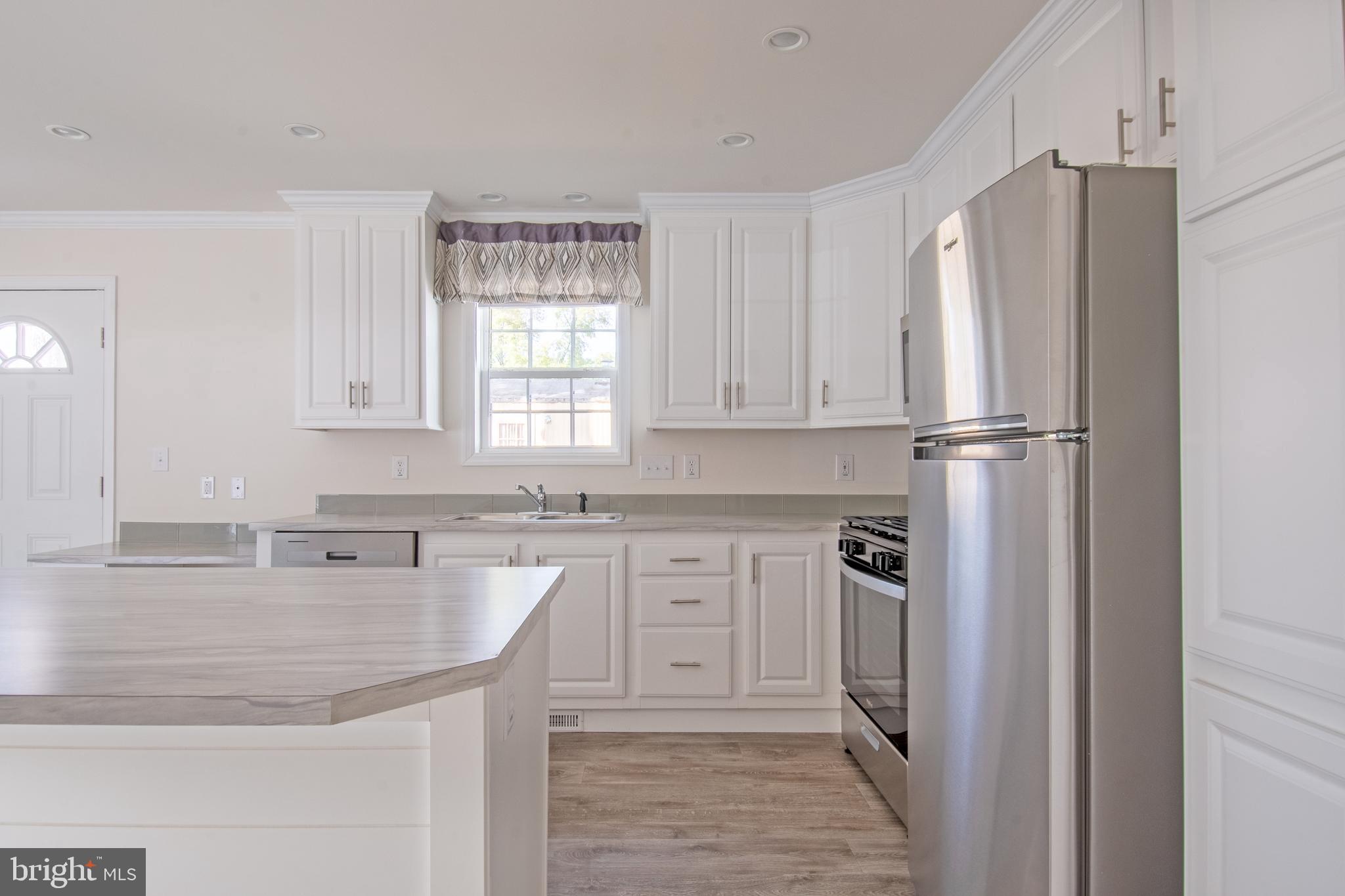 91 Longbow Lane Hartly, DE 19953 - Photo 7 of 21 a kitchen with stainless steel appliances granite countertop a refrigerator and a sink