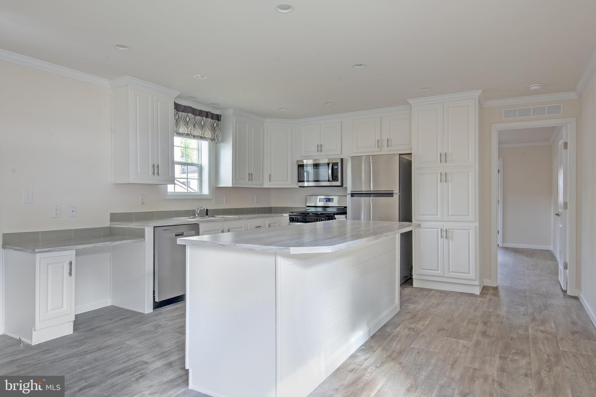 91 Longbow Lane Hartly, DE 19953 - Photo 8 of 21 a kitchen with stainless steel appliances a refrigerator sink and cabinets