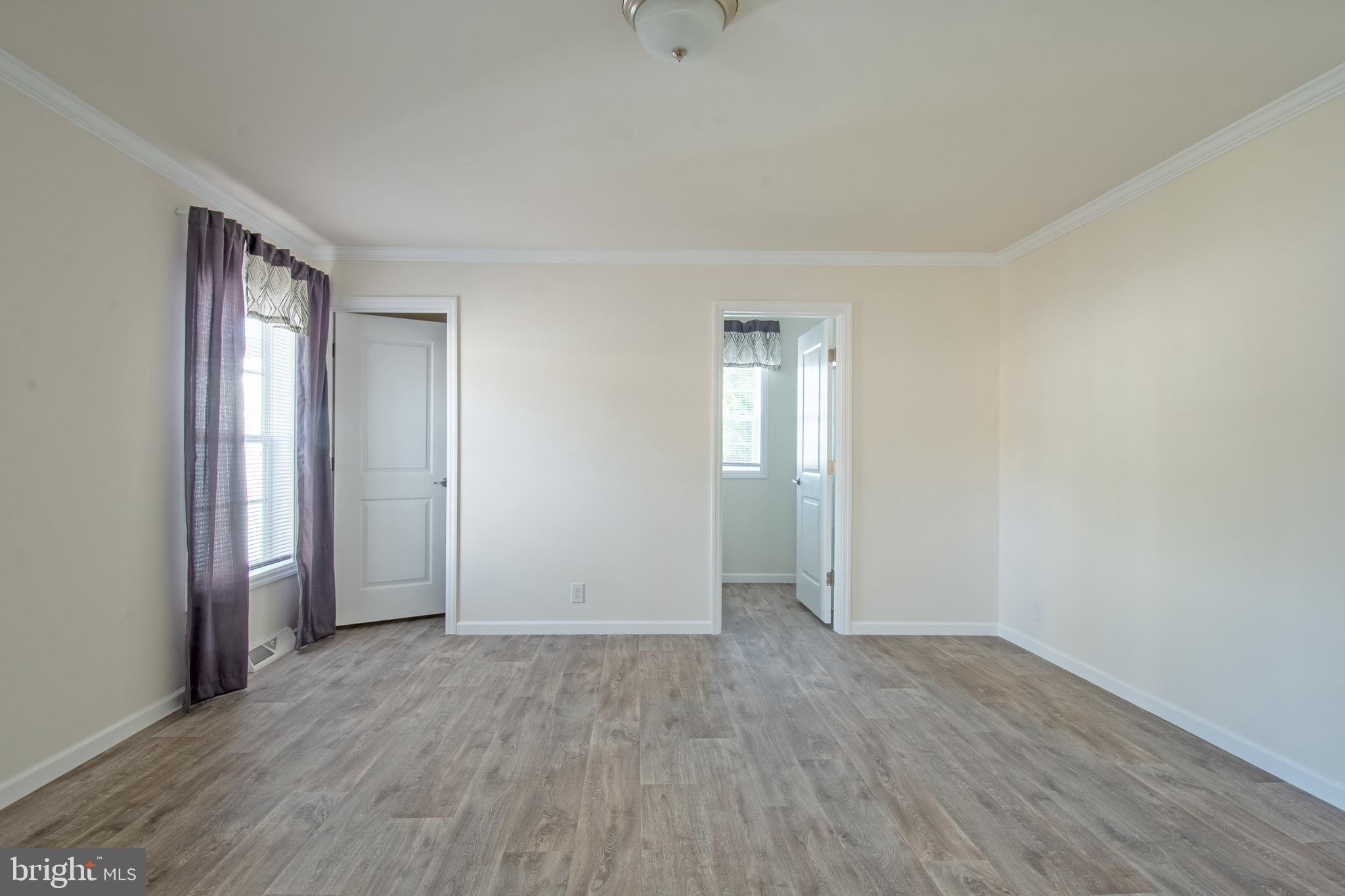 91 Longbow Lane Hartly, DE 19953 - Photo 10 of 21 an empty room with wooden floor and windows